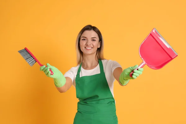Young Woman Broom Dustpan Orange Background — Zdjęcie stockowe