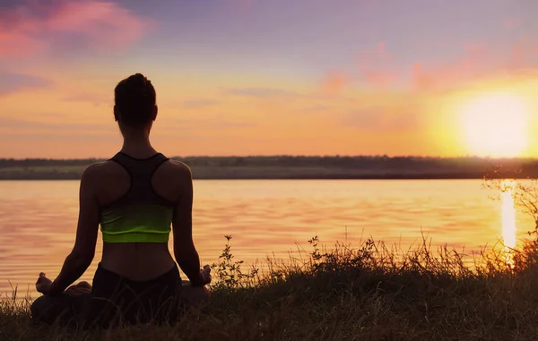 Kobieta Medytująca Nad Rzeką Zachodzie Słońca Widok Tyłu Ćwiczenie Jogi — Zdjęcie stockowe