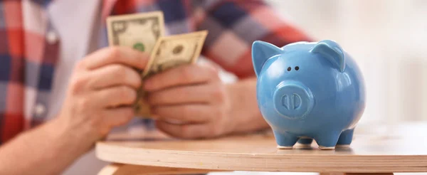 Man Met Geld Focus Spaarvarken Bank Houten Tafel Binnen Banner — Stockfoto