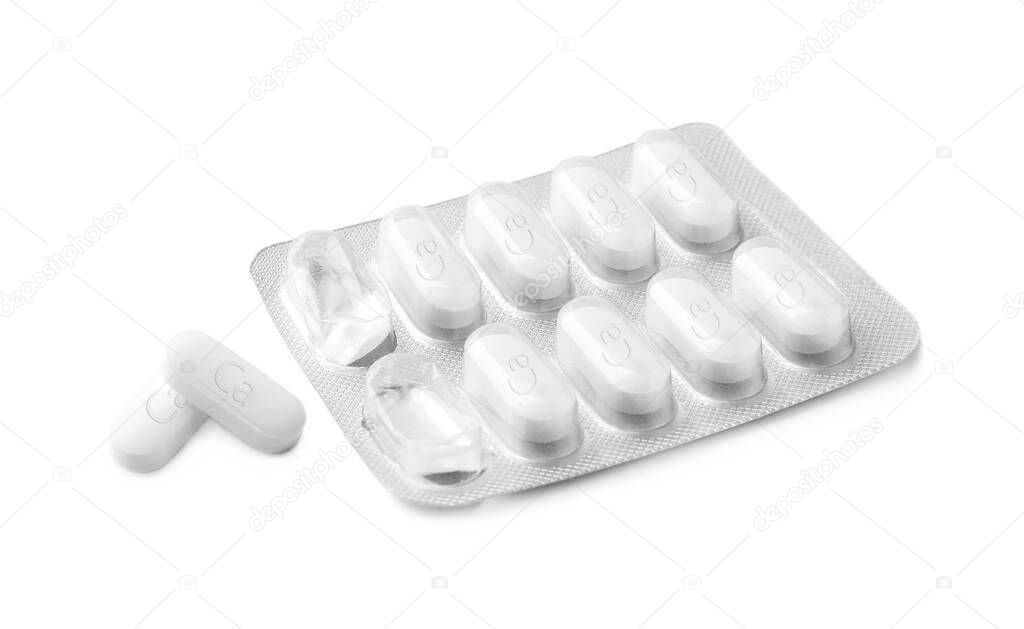 Blister pack with calcium supplement pills on white background