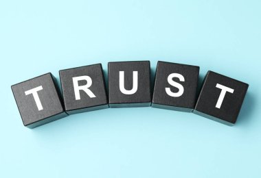 Word Trust açık mavi zemin üzerinde siyah küplerden yapılmıştır, düz uzanır