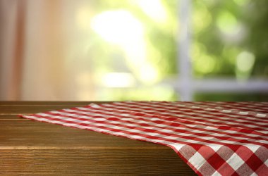 İçerideki ahşap masa üzerinde kırmızı ve beyaz kareli masa örtüsü, tasarım için yer. Bokeh etkisi