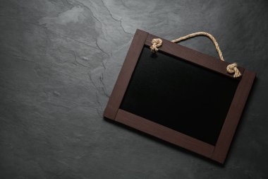 Masanın üstünde küçük siyah bir karatahta var. Metin için boşluk