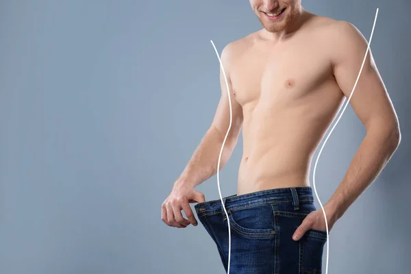 Vrolijke Jongeman Met Slanke Body Oversized Jeans Grijze Achtergrond Ruimte — Stockfoto