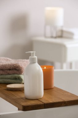 Banyoda banyo köpüğü, havlu ve mum dolu tepsi.