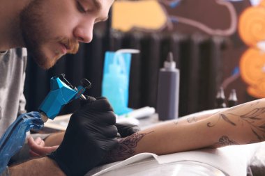 Profesyonel sanatçı kuaförde dövme yapıyor, yakın plan.