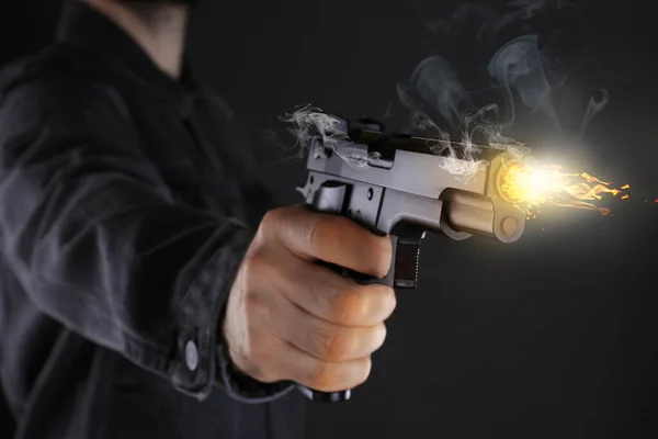 黒を背景に拳銃を撃つ男が接近 — ストック写真