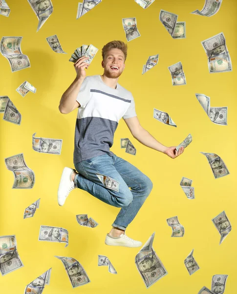 Щасливий Молодий Чоловік Грошима Падінням Американських Доларів Жовтому Фоні — стокове фото