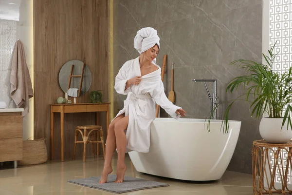 漂亮的女人坐在浴室浴缸边 — 图库照片