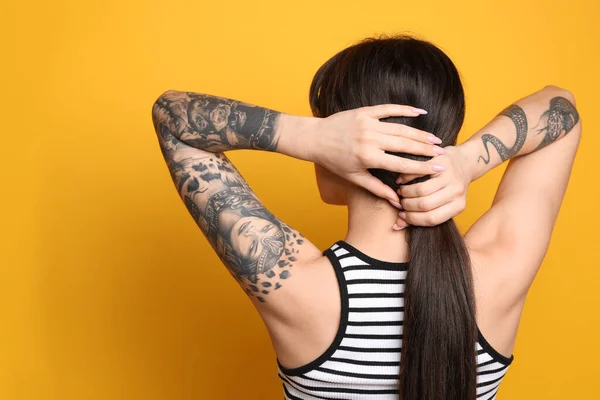 Όμορφη Γυναίκα Τατουάζ Στα Χέρια Κίτρινο Φόντο Πίσω Όψη — Φωτογραφία Αρχείου