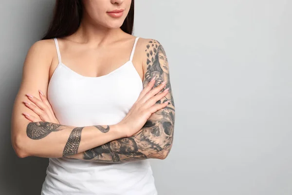 Mulher Bonita Com Tatuagens Nos Braços Contra Fundo Cinza Close — Fotografia de Stock