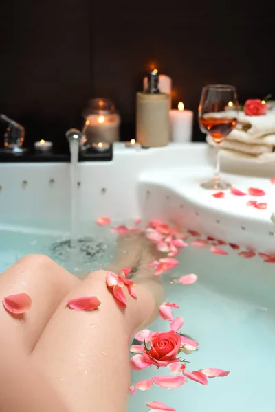 バラの花びらでお風呂に入る女性 閉じます ロマンチックな雰囲気 — ストック写真
