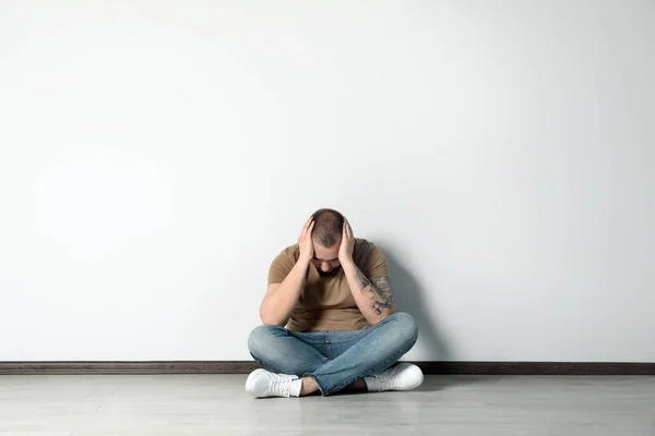 Joven Triste Sentado Suelo Cerca Pared Blanca Interior Espacio Para — Foto de Stock