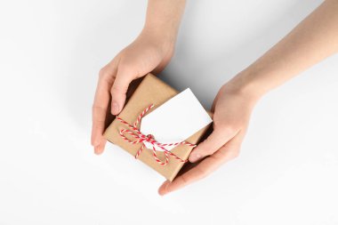 Beyaz arkaplanda etiketli bir pakete sarılı kadın, üst görünüm