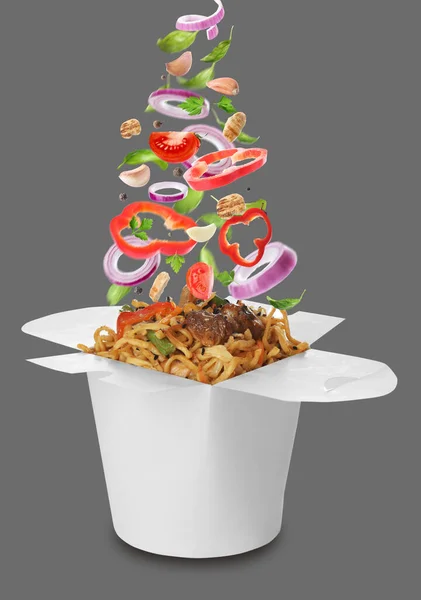 Different Fresh Ingredients Falling Box Wok Noodles Grey Background — Stock Photo, Image
