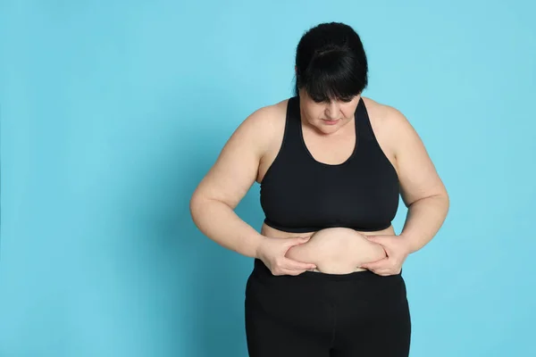 浅蓝色背景的肥胖妇女 体重减轻手术 — 图库照片