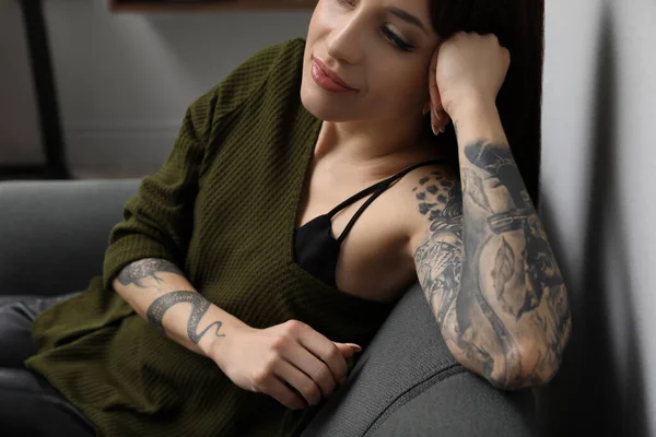 美しいです女性でタトゥーのある腕の中でリビングルーム クローズアップ — ストック写真
