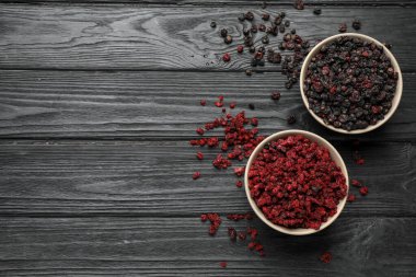 Kurumuş siyah ve kırmızı frenk üzümü ahşap masada, düz yerde. Metin için boşluk