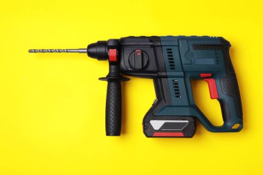 Modern elektrikli matkap ve sarı zemin üzerinde farklı parçalar, düz yatıyordu