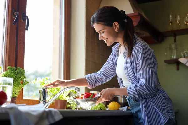 Genç Kadın Mutfak Lavabosunda Taze Dolmalık Biber Yıkıyor — Stok fotoğraf