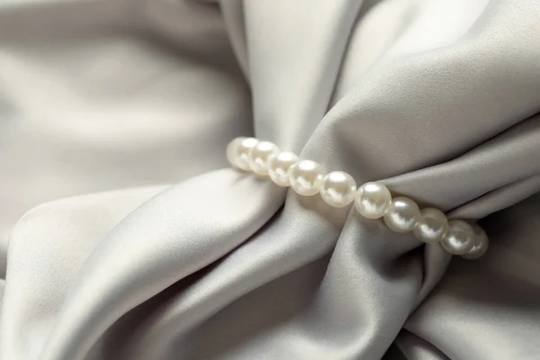 Elegantes Armband Mit Perlen Auf Grauer Seide Nahaufnahme — Stockfoto