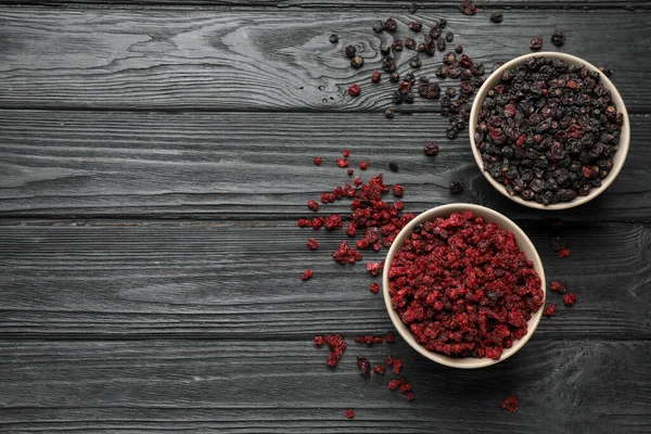 Kurumuş siyah ve kırmızı frenk üzümü ahşap masada, düz yerde. Metin için boşluk
