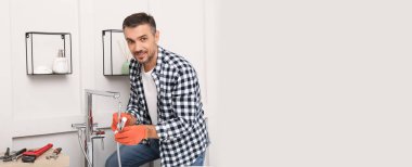 Tesisatçı banyoya yeni musluk kuruyor, mesaj için yer var. Pankart tasarımı