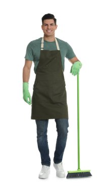 Beyaz arka planda yeşil süpürgesi olan adam.