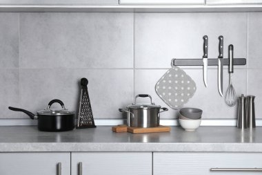 Gri tezgahta mutfak gereçleri ve yemek takımları