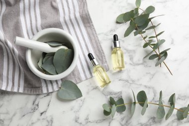 Beyaz mermer masa üzerinde okaliptüs şişeleri ile düz bileşim yatıyordu