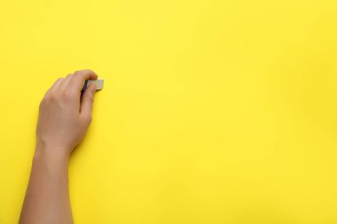 Adam sarı arkaplandaki bir şeyi siliyor, yakın plan. Metin için boşluk