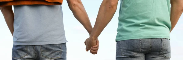 Gay Pár Drží Ruce Řeky Slunečného Dne Pohled Zezadu Návrh — Stock fotografie