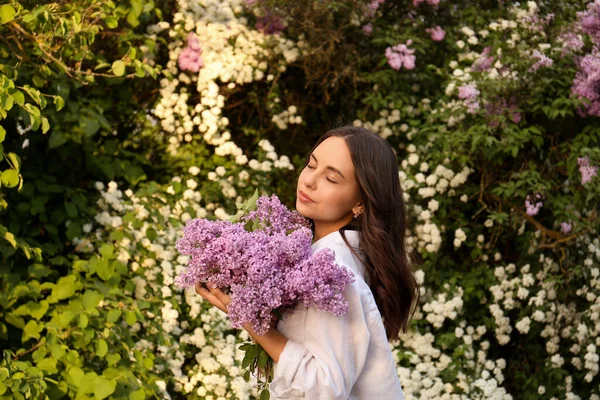 迷人的年轻女子 在户外开紫丁香花 — 图库照片