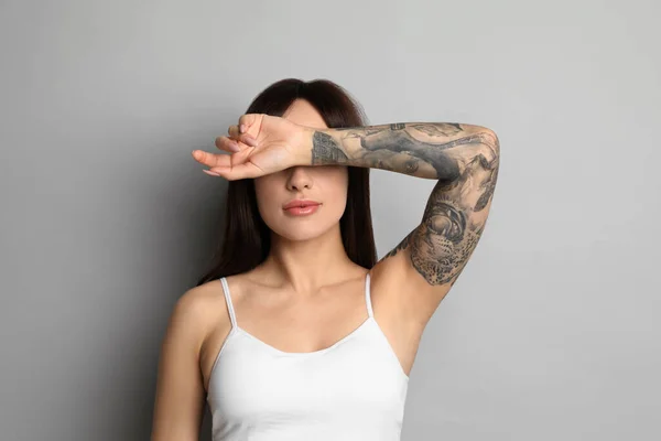 Belle Femme Avec Des Tatouages Sur Bras Sur Fond Gris — Photo