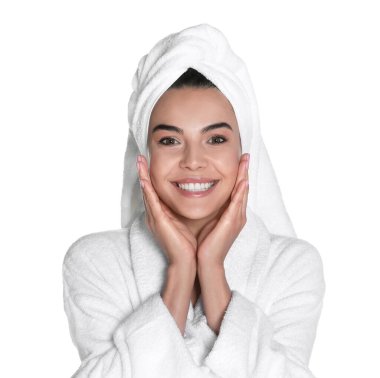 Beyaz arka planda bornoz ve havlu giymiş güzel genç bir kadın.