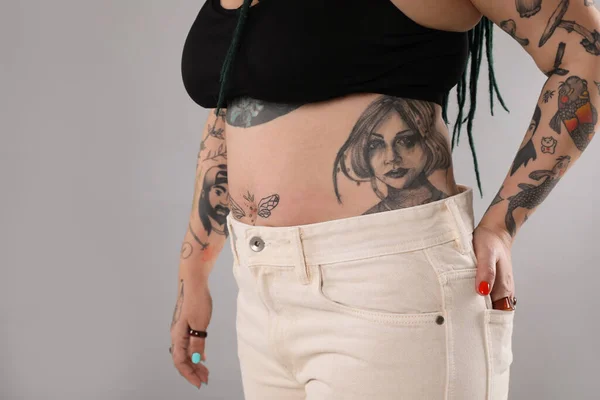 グレーを背景に体に入れ墨を持つ女性 クローズアップ — ストック写真