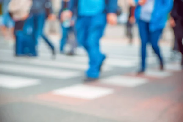 People crossing street outdoors, closeup. Blurred view