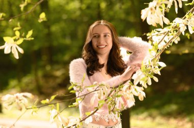 Bahar gününde çiçek açması tree yakınındaki güzel genç kadın