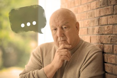 Senior man suffering from dementia indoors. Illustration of speech bubble with ellipsis clipart
