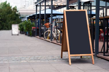 Açık kafenin yanındaki boş ahşap sandviç tahtası. Tasarım için model