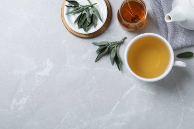 Açık gri masada aromatik adaçayı eşliğinde düz bir kompozisyon. Metin için boşluk