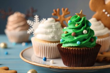 Açık mavi ahşap masa üzerinde nefis bir Noel ağacı keki, yakın çekim manzarası. Metin için boşluk