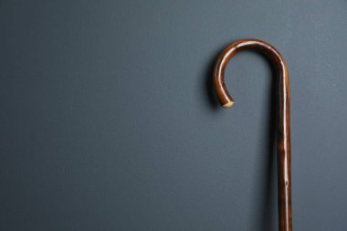 Gri arka planda zarif tahta baston, yakın plan. Metin için boşluk