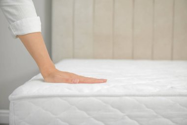 İçerideki yumuşak beyaz şilteye dokunan kadın, yakın plan. Metin için boşluk