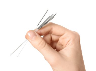 Beyaz arka planda akupunktur için iğneler tutan kadın, yakın plan
