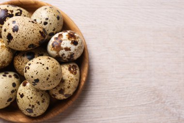 Beyaz ahşap masada taze bıldırcın yumurtaları, üst manzara. Metin için boşluk