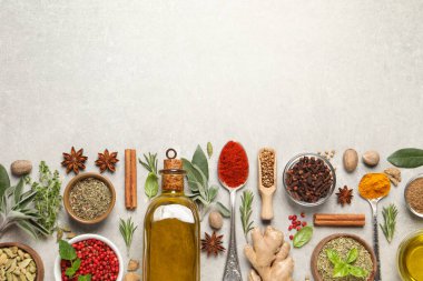 Farklı otlar ve baharatlar gri masada, düz yerde. Metin için boşluk