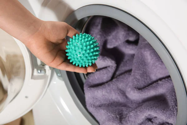 緑色のドライヤーボールを洗濯機に入れる女性は 上記のビュー — ストック写真