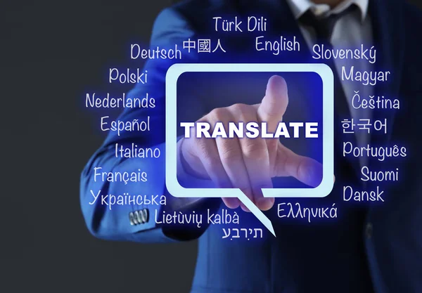 Translator pointing at virtual screen with names of different languages on grey background, closeup