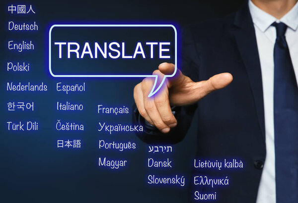 Translator pointing at virtual screen with names of different languages on dark blue background, closeup